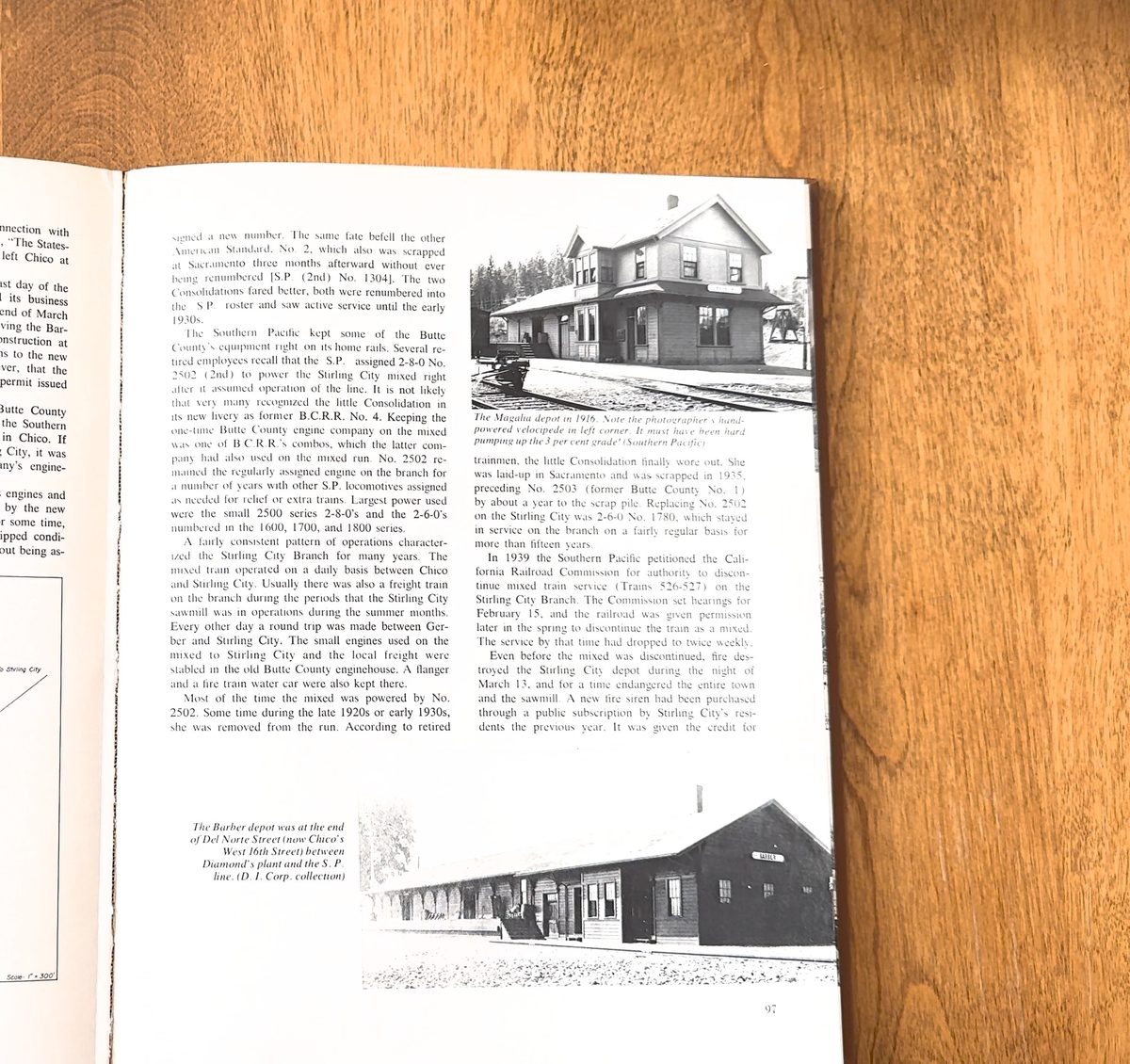 A frame from the video: the right-hand page of an open book on a wooden table, two columns of text with a photograph of a railroad depot set into the page
